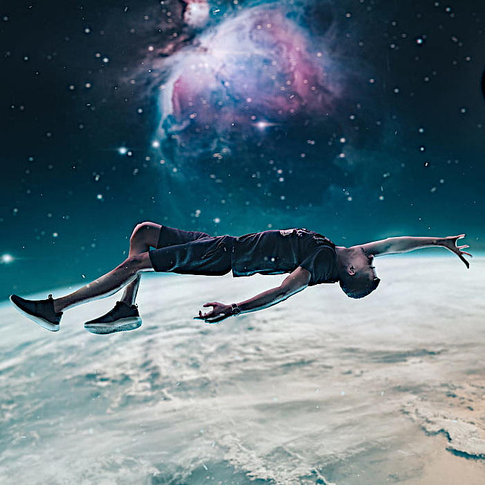 Joven flotando en el espacio mientas escucha música